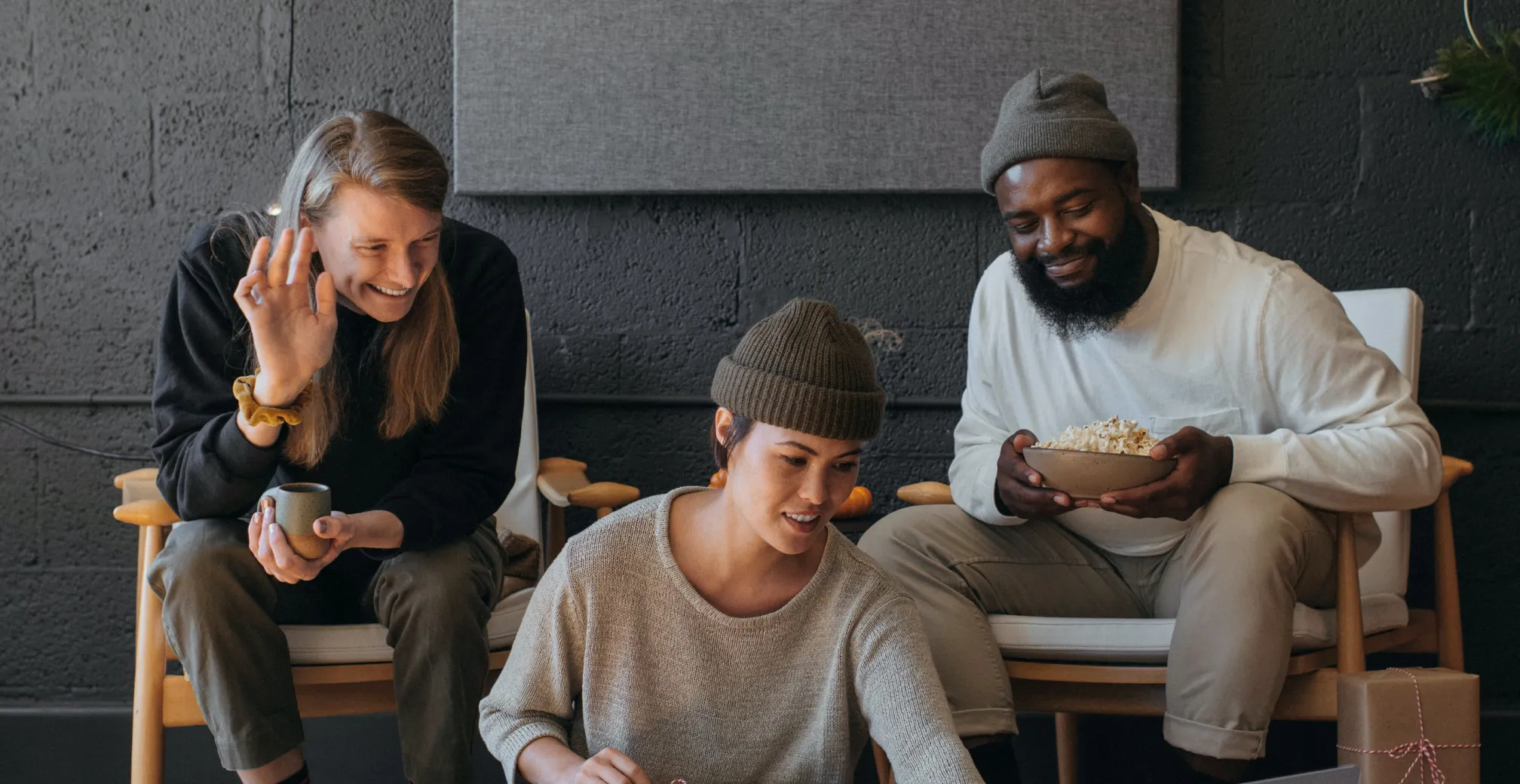 Three people sitting in chairs, one of them is smiling.